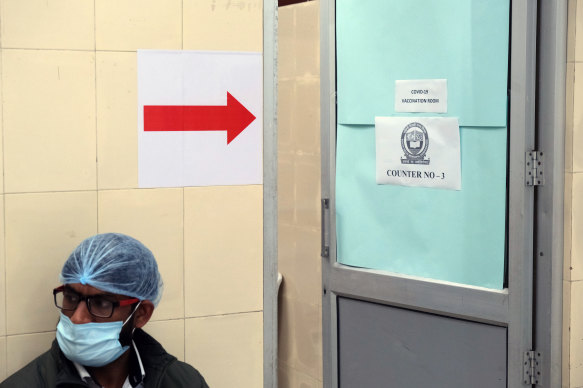 A healthcare worker waits outside a vaccination centre in New Delhi.