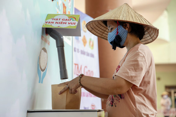 A person wearing a protective mask collects rice from a "rice ATM" at a distribution centre during a partial lockdown imposed due to the coronavirus in Ho Chi Minh City, Vietnam.
