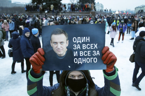A protester in St Petersburg on January 23 holds up a sign with a Alexei Navalny and the slogan “One for all and all for one”.
