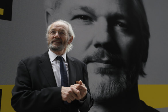 Julian Assange’s biological father John Shipton stands in front of his poster near the Central Criminal Court Old Bailey in London.