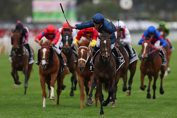 John Allen raises the whip to celebrate his VRC Oaks victory on Strictly Business.