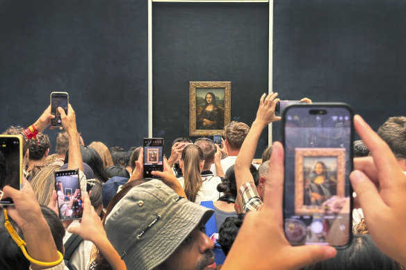 Crowds jostle to see the Mona Lisa at the Louvre.