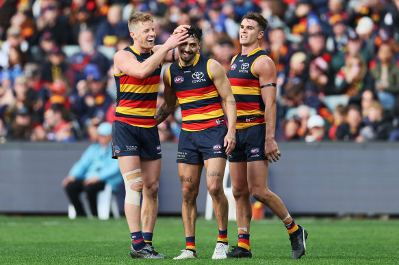 Izak Rankine (centre) celebrates one of his five goals with Rory Sloane and Ben Keays.