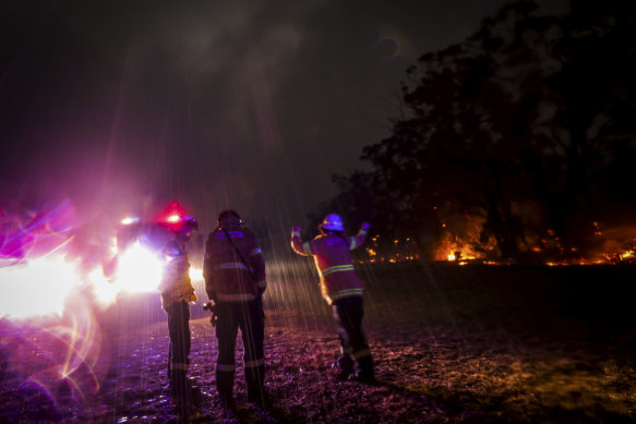 Firefighter Mikaela Kremer from Glenbrook-Lapstone does a dance to celebrate the rain suddenly falling just as they were responding to spotting from Green Wattle Creek bushfire.