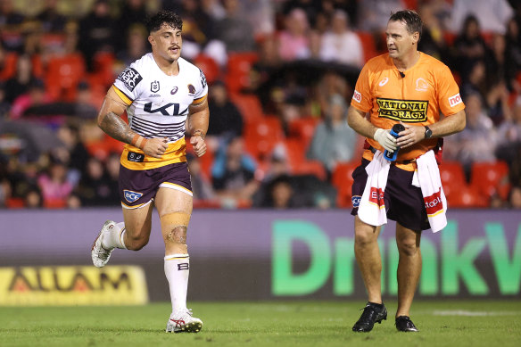 Kotoni Staggs of the Broncos leaves the field with a trainer at BlueBet Stadium.