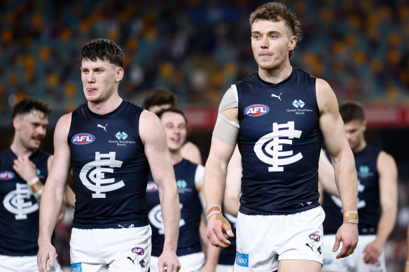 Vice-captain Sam Walsh and captain Patrick Cripps lead the dejected Blues off the Gabba after their elimination final loss.