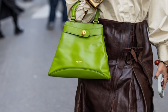 10월 파리 패션위크에 참석한 게스트가 프라다 핸드백을 들고 있습니다.