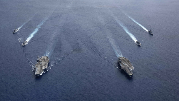 The USS Ronald Reagan and USS Nimitz carrier strike groups steam in formation, in the South China Sea, last month.