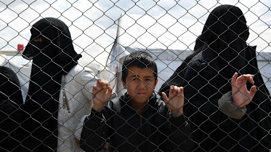 Foreign ISIS wives and children at the fence line of the Foreign section of al-Hawl camp.