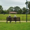 Two parkgoers relax on a bench at Centenary Park, Bentleigh East. 