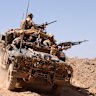 An Australian surveillance reconnaissance vehicle patrols an operating base in Afghanistan in 2005.