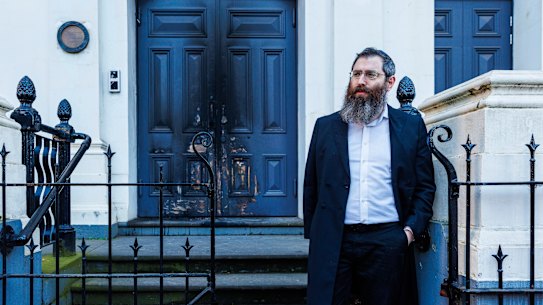 Rabbi Dovid Gutnick outside the charred entrance to the East Melbourne Synagogue.