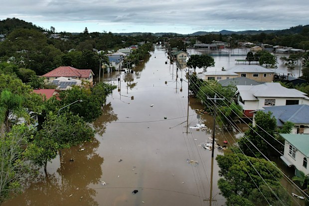 An aerial drone view of houses surrounded by floodwater in Lismore, NSW