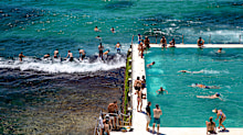 People are seen jumping into the water at South Bondi next to the Icebergs pool at Bondi Beach.