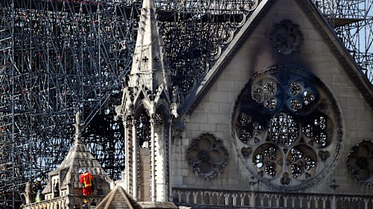 A fire fighter makes his way on a balcony of Notre Dame cathedral Wednesday, April 17, 2019 in Paris. French President Emmanuel Macron ratcheted up the pressure by setting a five-year deadline to restore the 12th-century landmark. (AP Photo/Francois Mori)