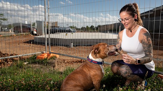 Sam Reichstein and her dog Goose play in front of a block of land that she recently bought in Throsby, one of the ACT's most expensive suburbs. Photo: Sitthixay Ditthavong