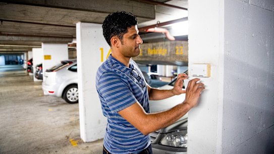 Dr Akhil Gupta in his carpark with his now petrol car and the electric power plug that was removed so he couldn’t power his electric vehicle.