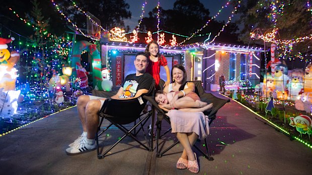 James and Kerryn Drmic, and daughters Zadie (in red) and Pia,outside their Christmas lights display.