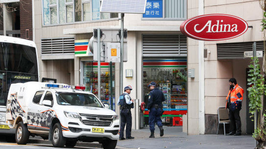 Travellers being escorted off a bus by police into hotel quarantine for 14 days.