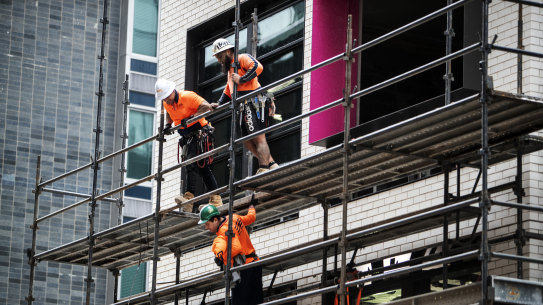 Workers are seen taking down cladding ahead of the first view of the North Sydney Metro.