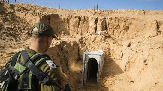 An Israeli soldier stands on the Israeli side of the border with Gaza, near the opening of a tunnel, that Israel says was dug by the Islamic Jihad militant group, leading from Gaza into Israel.