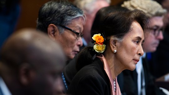 Myanmar's leader Aung San Suu Kyi and Gambia's Justice Minister Aboubacarr Tambadou, left, listen to judges in the court room.