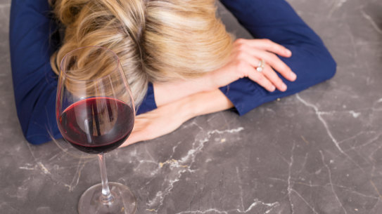 Depressed woman with wine glass resting her head on kitchen counter Talking Wine, wine additives story for Good Food Mag Online Feb 2020 iStock photo