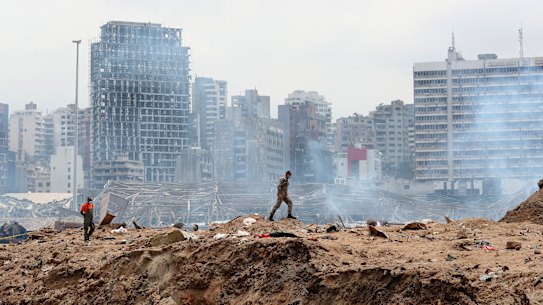 A soldier walks past the crater left by the devastating explosion at the Port of Beiriut. 