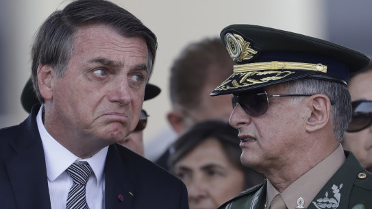 Brazilian President Jair Bolsonaro, left, talks with Army Commander General Edson Leal Pujol, during a military ceremony. Pujol has resigned along with the chiefs of the navy and the air force. The Armed Forces have repeatedly said they would not be drawn into politics.