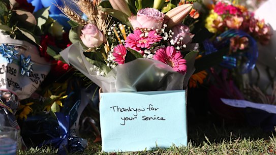 Tributes are seen at Chinchilla Police station in Chinchilla, Queensland, Wednesday, December 14, 2022. Police have shot dead three people at a remote property on Queensland’s Darling Downs after an ambush in which two officers and a bystander were killed. (AAP Image/Jason O’Brien) NO ARCHIVING AAP fee for use 
