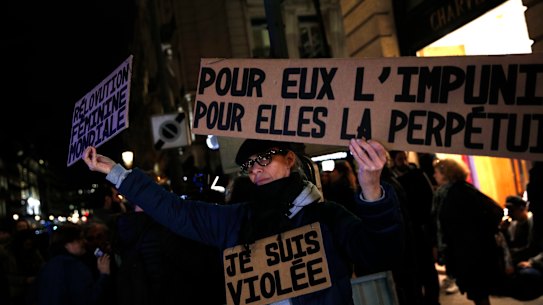 An activist holding a banner reading: “For him impunity, for her a life sentence” during a protest in Paris after a 2017 sexual assault case the court refused to upgrade to rape. 