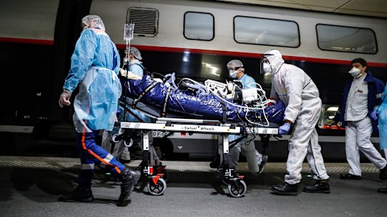 Medical staff transfer a patient infected with the coronavirus in Paris. 