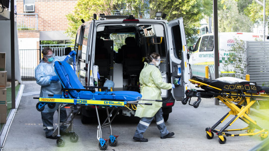 Aged care workers and ambulance staf outside a Sydney aged care facility last year.