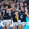 Carlton players get around Matthew Owies after his goal against Richmond.