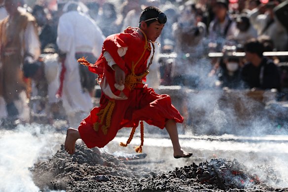 A buddhist monk jump over burning wood sticks during annual “Hiwatari Matsuri” Fire walking festival at Takaosan Yakuoin Temple on March 08, 2026 in Tokyo, Japan. Led by mountain ascetics chanting esoteric prayers, barefoot worshippers file across the smoking embers to seek protection, long life and relief from misfortune. 