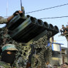 Palestinian masked members from the Izzedine al-Qassam Brigades, a military wing of Hamas, ride next to a rocket launcher during a rally in Rafah refugee camp, Gaza Strip, in 2016.