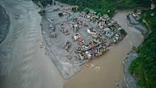 A drone view shows houses damaged by flash floods surrounded by sludge, mud and debris along the swollen Trishuli River in Devighat, Nepal.