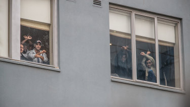 Some of the 65 male refugees and asylum seekers detained at the Mantra Hotel in Preston watch the protest from a window.