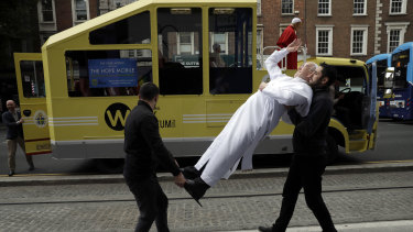 A recently unveiled waxwork of Pope Francis is carried from the National Wax Museum to be put on a refurbished 1979 Popemobile in Dublin, Ireland.
