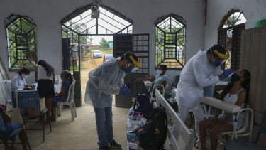 Health workers test people for COVID-19 at the Indigenous Park, a tribal community in the outskirts of Manaus, Amazonas state, Brazil, where medical care is scarce.