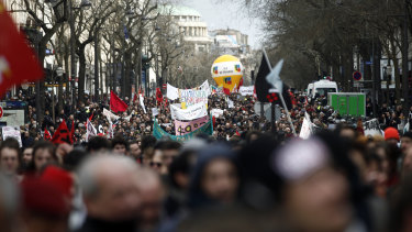 Demonstrators march to protest against pension reform plans in Paris on Tuesday, ahead of votes in the National Assembly.