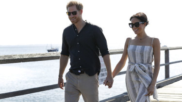 Prince Harry and Meghan walking along Kingfisher Bay Jetty during a visit to Fraser Island on Monday.