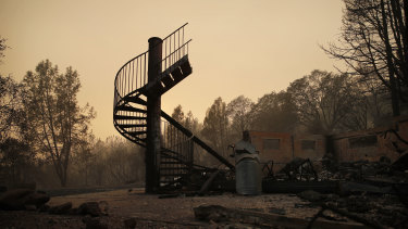 A spiral staircase stands in the remains of a burned out home in Paradise, California.