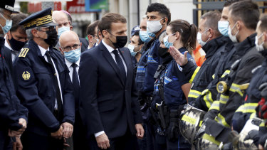 French President Emmanuel Macron meets police and rescue workers outside the cathedral in Nice.