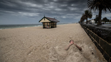 Nine-year-old Elisha and his mother Wendy are the last people on the beach before the storm engulfs the shore on Thursday. 