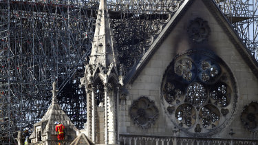 A firefighter makes his way on a balcony of Notre-Dame Cathedral.