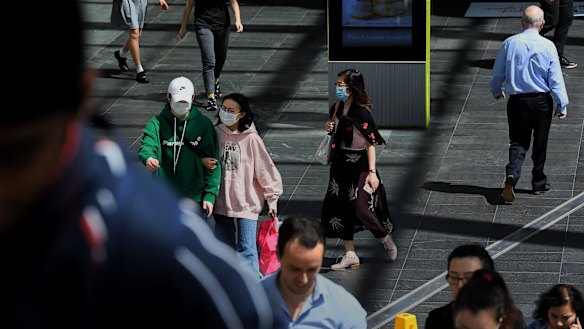 People with face masks walking along the street in Chatswood.