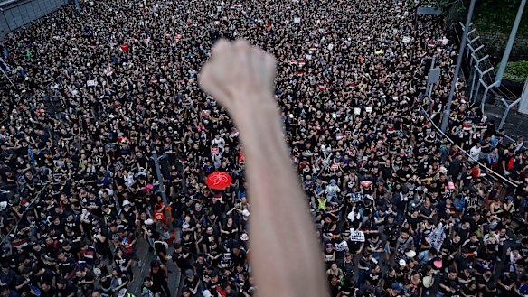 A protester clenches his fist as tens of thousands of protesters march on the streets to stage a protest against the unpopular extradition bill in Hong Kong.