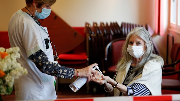 Josiane Cohen, right, is given hand sanitiser before meeting her daughter Laetitia at the Kaysersberg nursing home in eastern France.