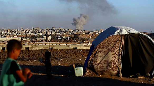 Smoke rises following an Israeli airstrike on buildings near the separating wall between Egypt and Rafah, southern Gaza Strip.